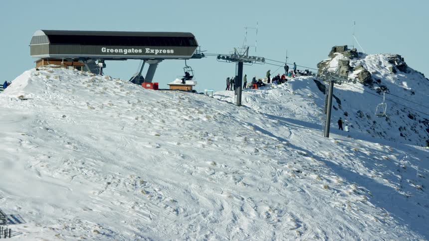 People are riding the ski lift on the slope