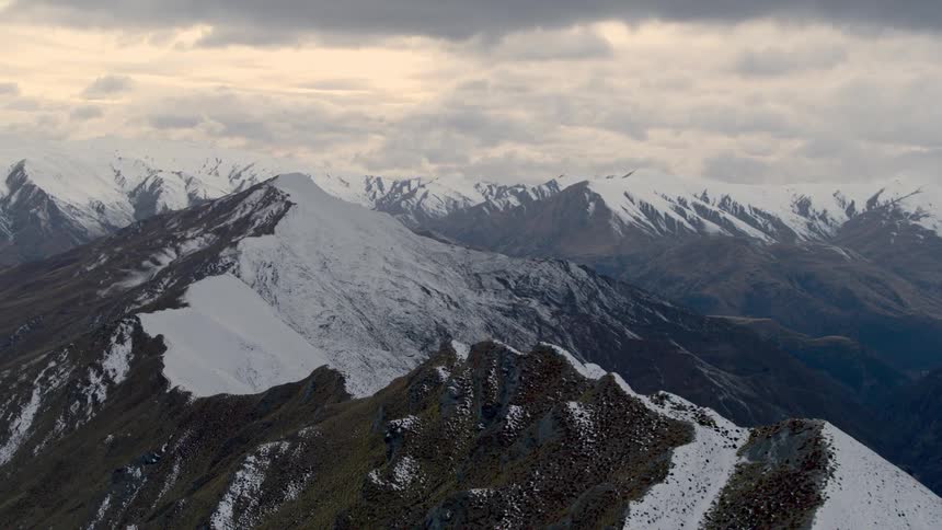 Snowcovered mountain range with jagged peaks under a cloudy sky