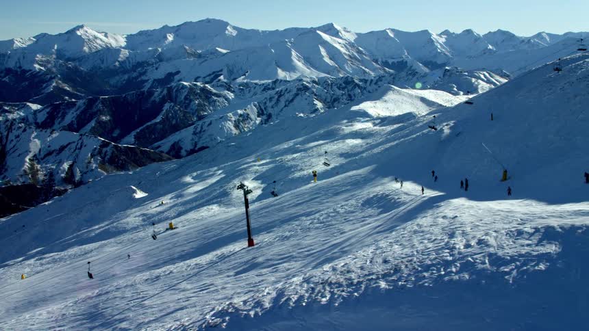 Aerial view of skiers on a snowcovered mountain near a ski lift station