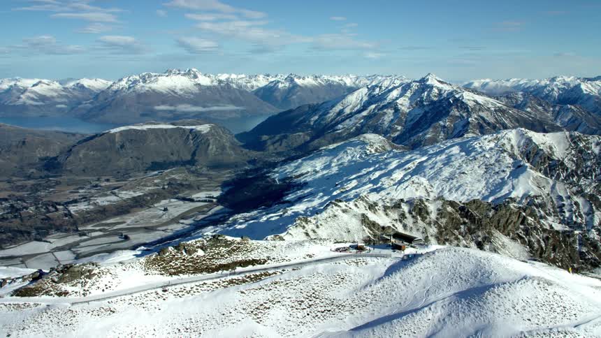 A range of snowcapped mountains that stretch to the horizon in resort town Queenstown
