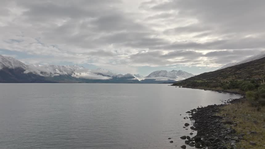 Tranquil landscape of a lake surrounded by snowcapped mountains