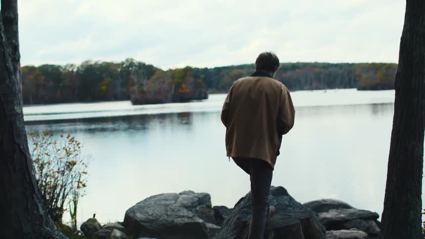 A man steps up to the shore and takes a photograph