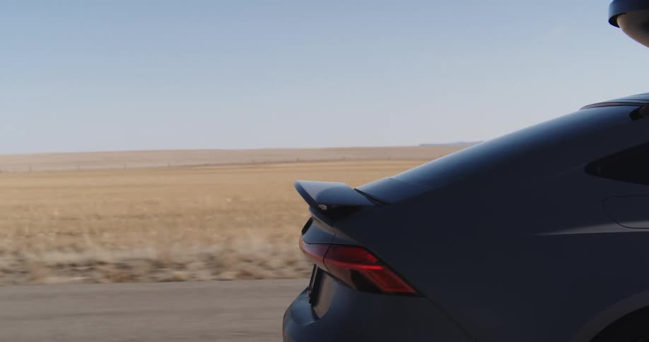 A car is driving down the empty road
