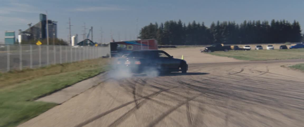 A car is drifting on the dirt track