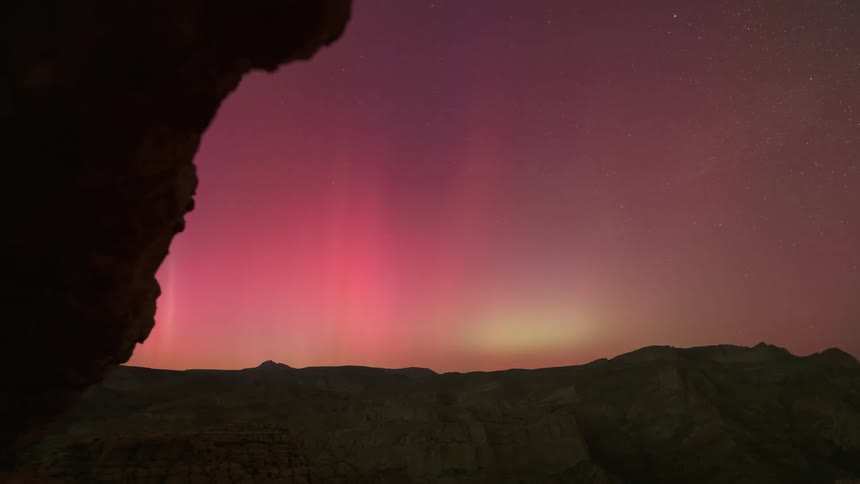 Time lapse of northern lights over a desert at night