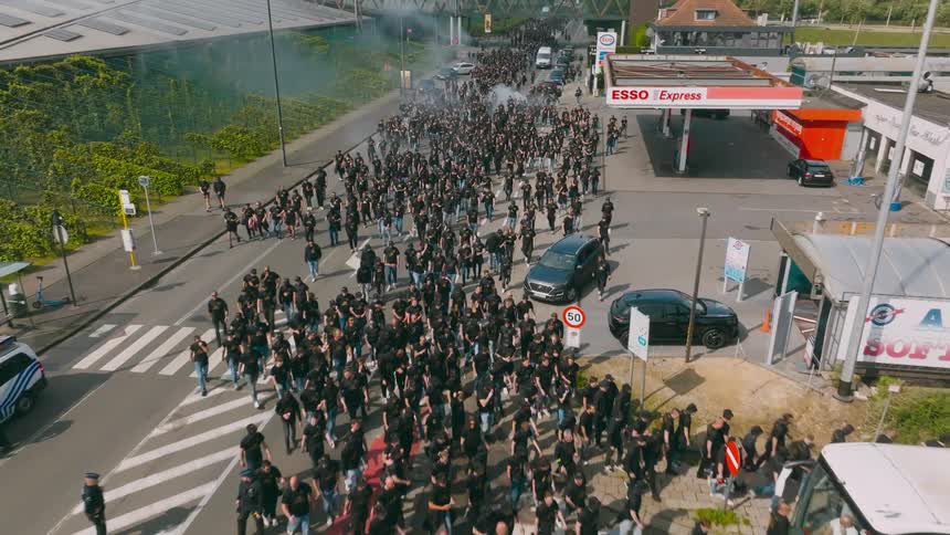 A crowd of protestors are marching down the road