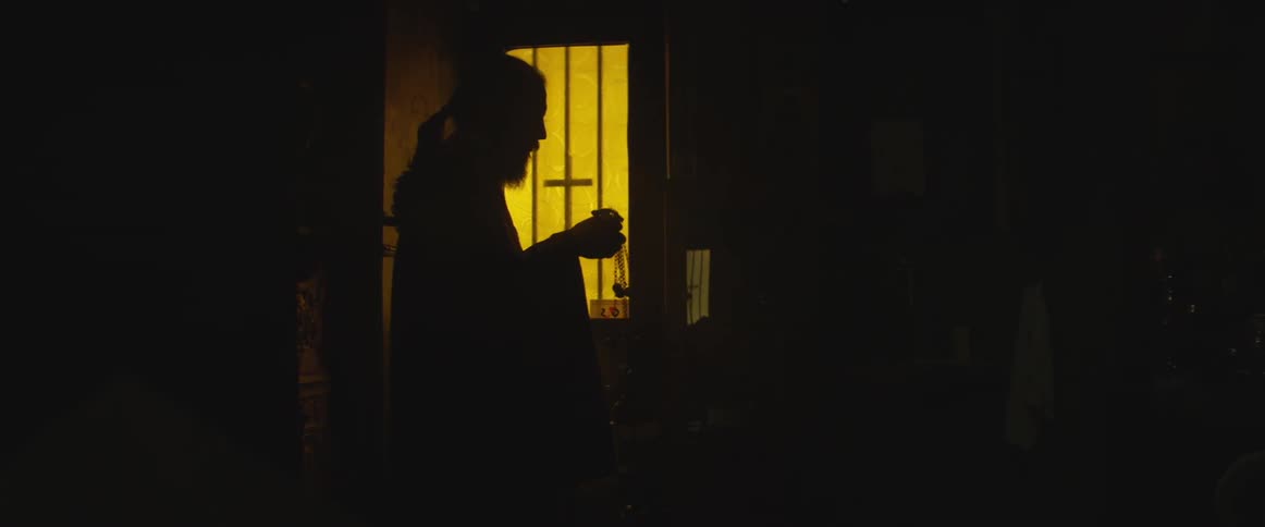 A bearded man waves a censer