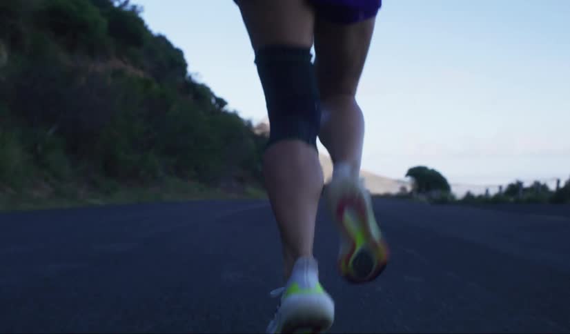 Woman running on a road focusing on her sneakers and lower legs