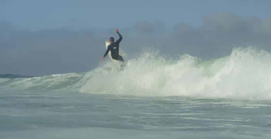 A surfer jumps and falls into the ocean