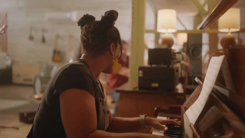Female pianist works with her band to write a song