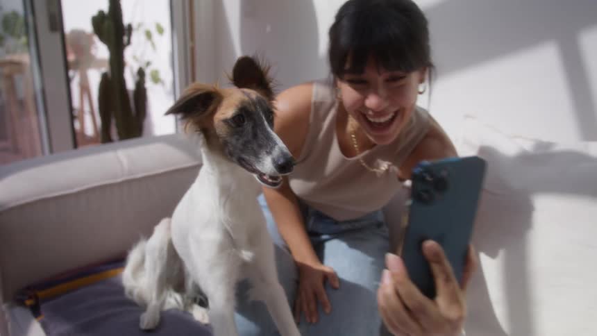 Woman talking in selfie with her dog by her side