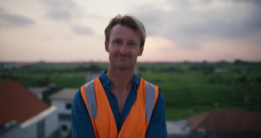A man is smiling by the homes