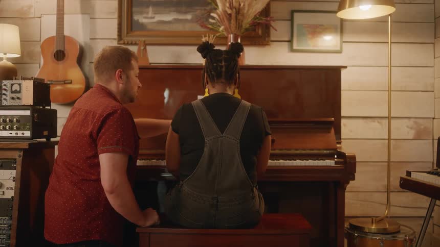Two musicians collaborating at the piano