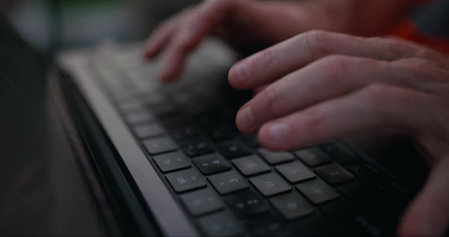 A man is typing on his laptop