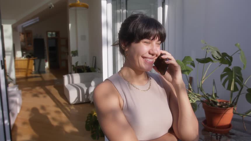 A woman smiles as she talks on the phone