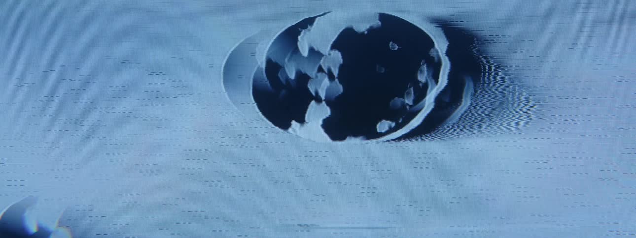 A closeup of a blue screen with a distorted circular area moving up
