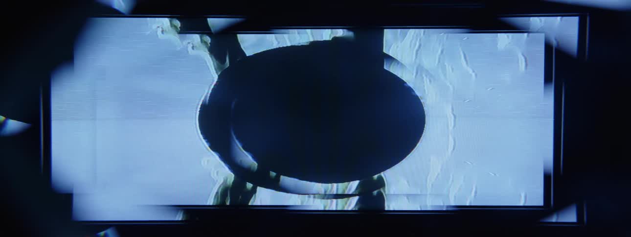Animation on computer screen flickers as pale and dark streaks blend into a dark oval
