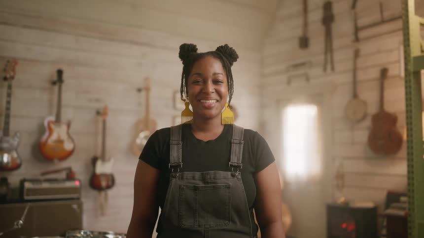 A black female musician laughing in a music studio