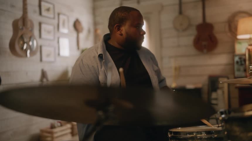 Concentrated man in a studio playing the drums