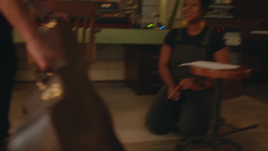 A man carries his guitar case into the studio