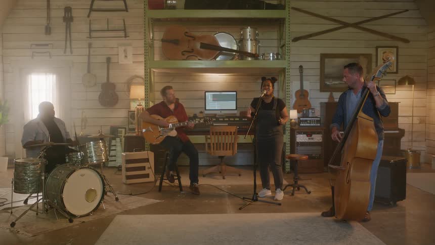 Four musicians perform together inside a studio