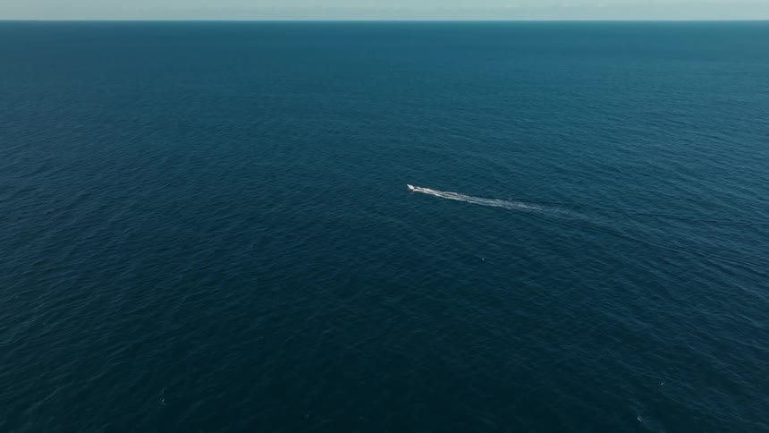 An aerial clip of a boat sailing the sea
