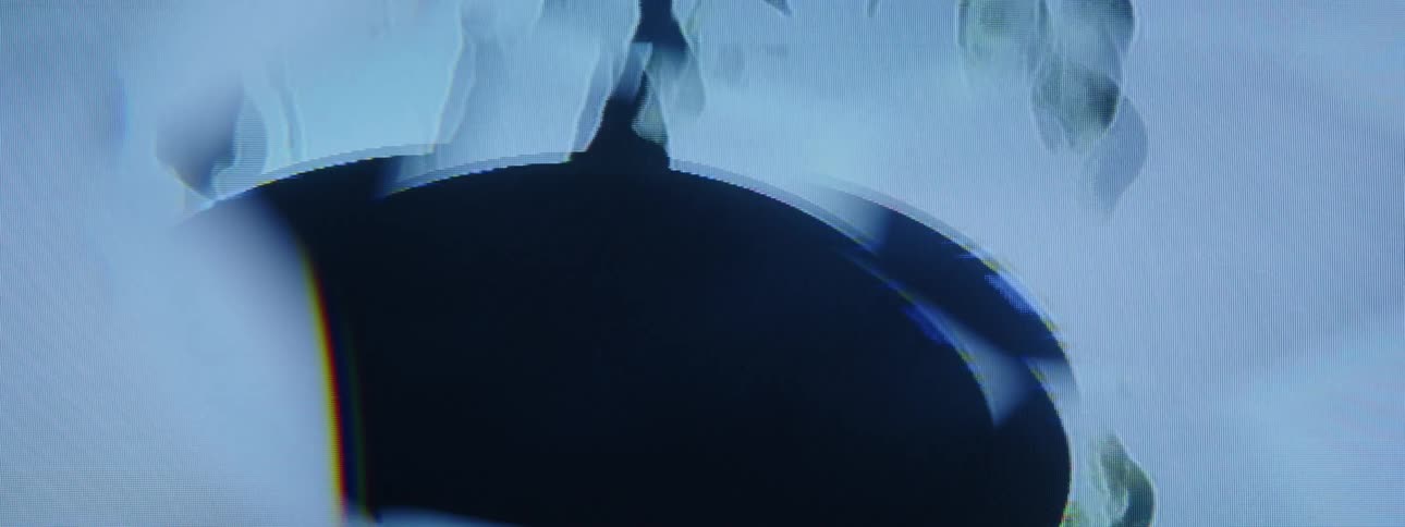 A closeup of a blue screen with a distorted circular area moving up