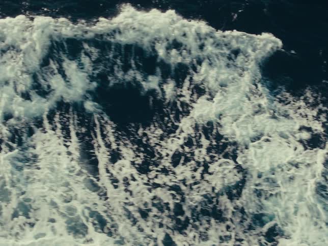Waves crash on the ocean below