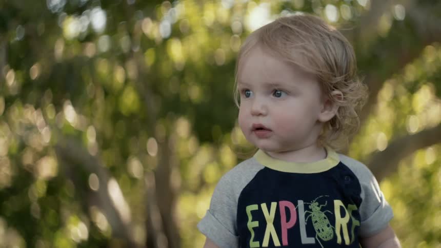 A toddler smiles and points