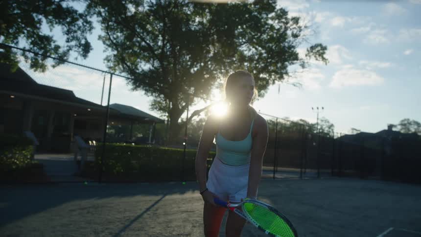 Woman jumping and serving a tennis ball with her racket