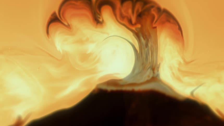 Close up of a yellow and cream liquid mixing and blooming