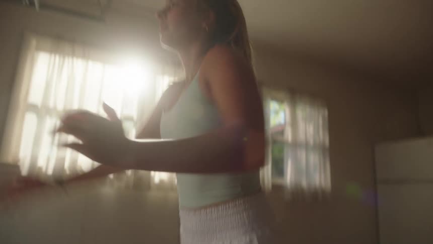 Concentrated woman jumping and doing squats indoors