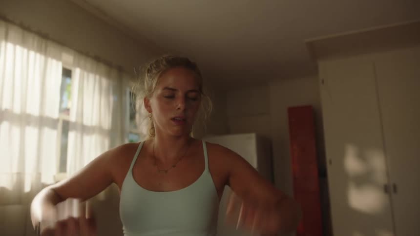 Portrait of a woman indoors with her hands on her head sweaty and tired