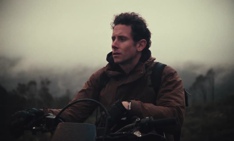 Man sitting on a motorcycle on a foggy hill
