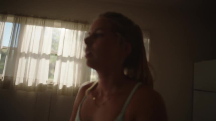A young woman stretches inside of a room
