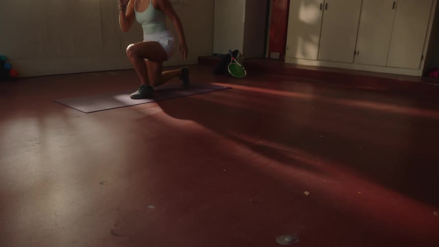 Legs of a woman doing stretching exercises on a yoga mat jumping and squatting