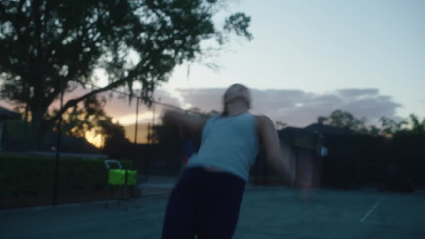 Woman throwing up a tennis ball and serving it with a racket