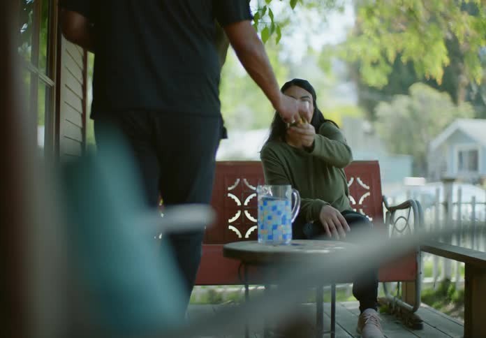 A man and woman drink water on the porch