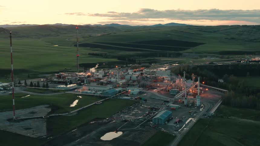 A petroleum refinery is surrounded by grass fields