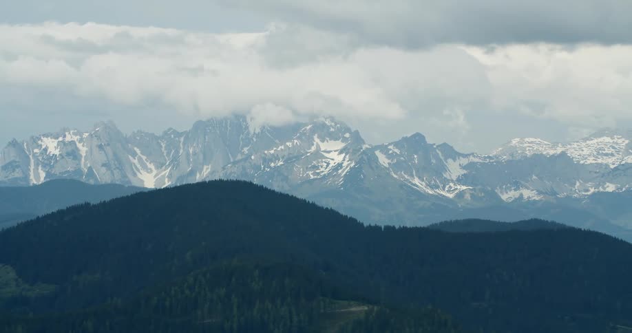Aerial panorama of mountains with forests in the foreground and snowcovered mountains on the horizon