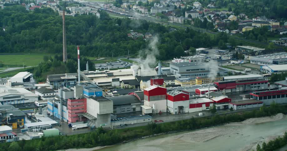 Aerial panorama and an industrial zone on the bank of a river like chimneys releasing smoke