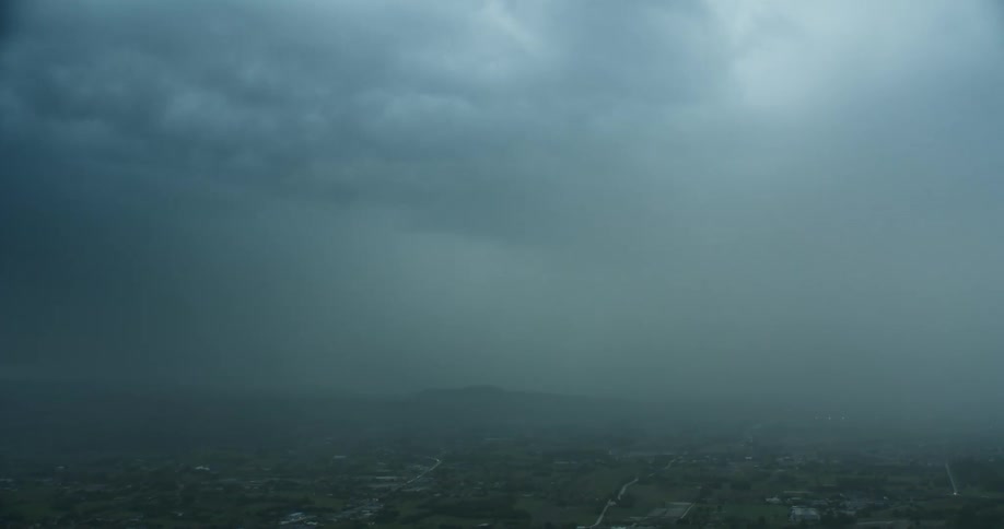 A thunderstorm with lightening moves over a rural community