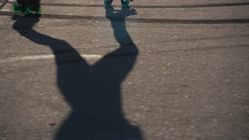 A woman roller skating is giving off a shadow