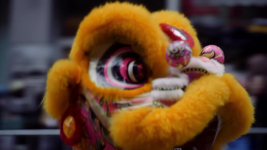 Chinese dragon passing by on a street surrounded by a crowd of people at an asian festival
