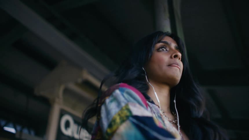 Young woman at a train station with earphones