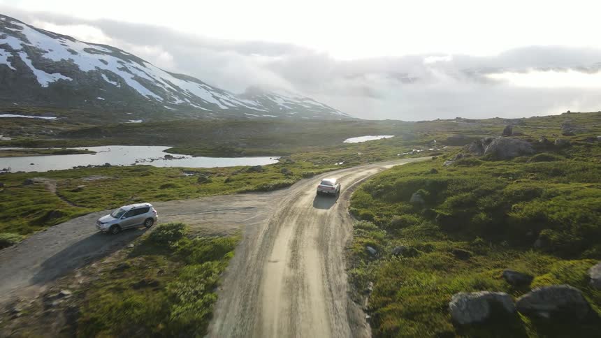 Car traveling along a long street surrounded by snowy mountains