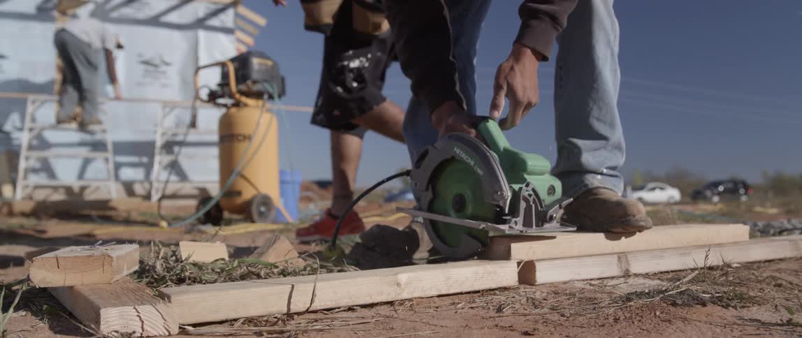 A man saws a plank of wood in half