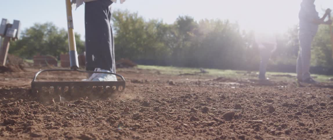 A man rakes through dirt