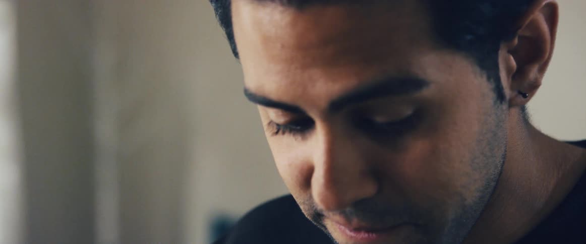 A young man turns away while focusing on his work