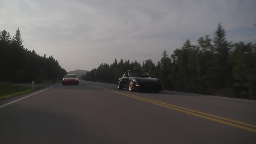 Classic Porsche sport car overtaking on a highway with trees around
